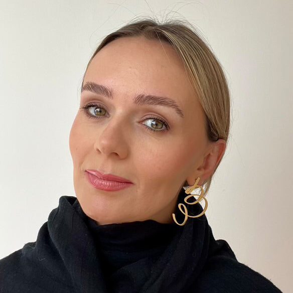 Woman wearing stainless steel gold plated stud earrings